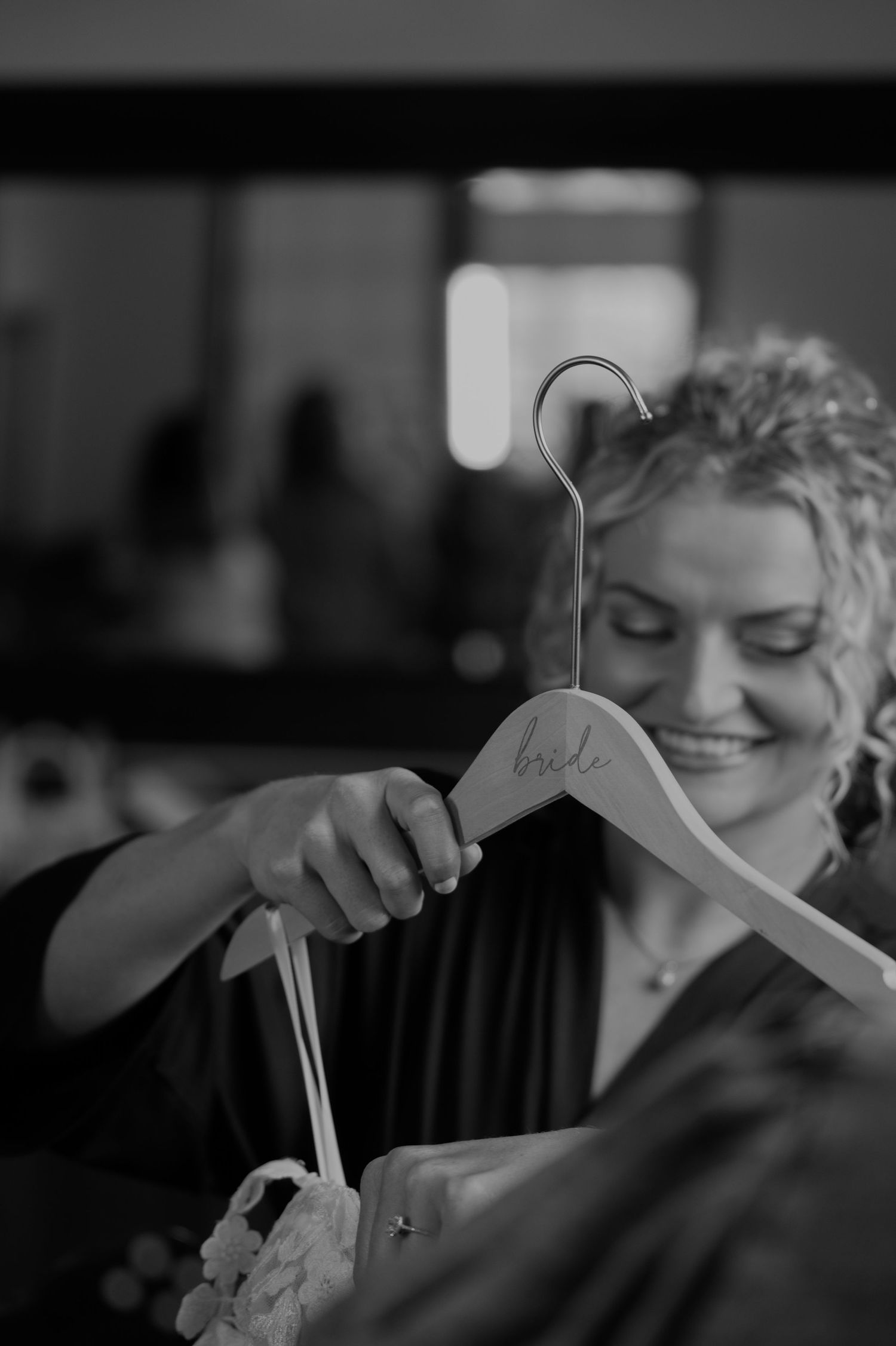 Black and white image of wedding dress hangers in preparation room.