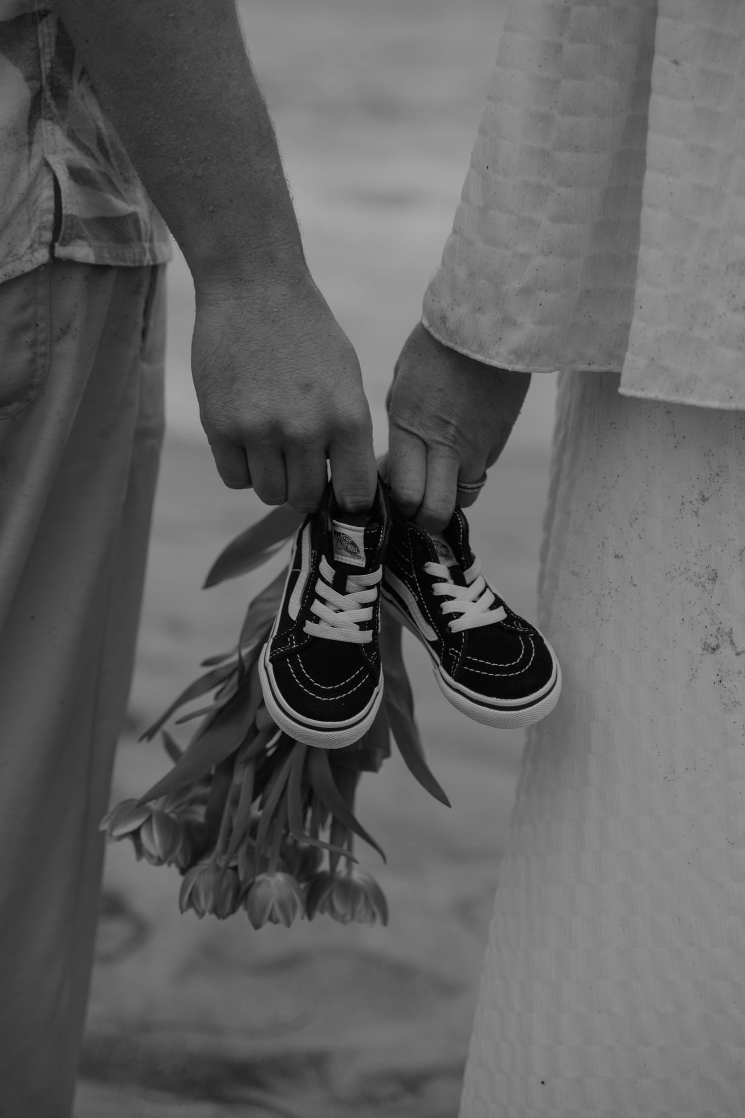 Black and white detail shot of shoes during a beach photoshoot.