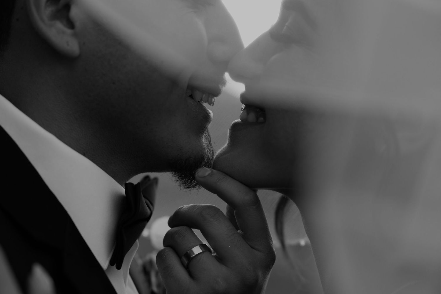 A close-up black and white photo capturing an intimate wedding moment.