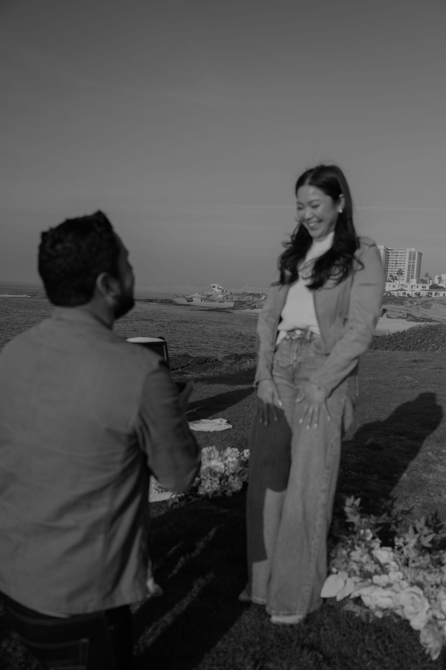 Couple enjoying a scenic coastal view together on a cloudy day.