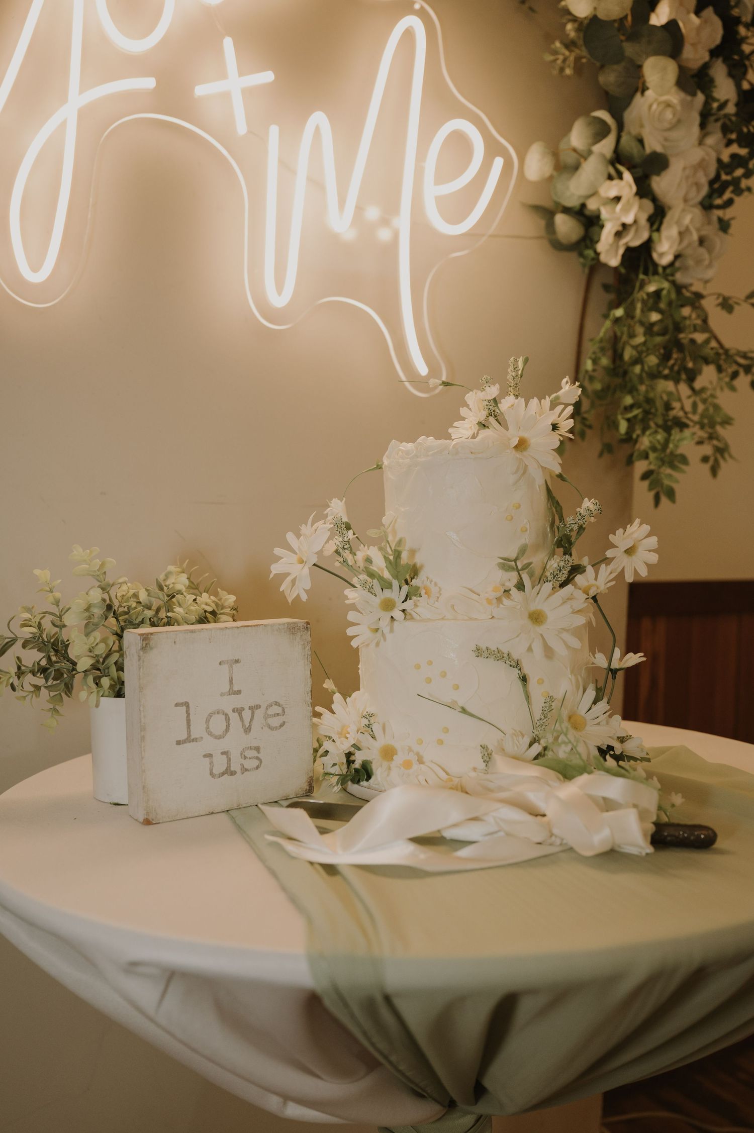Wedding reception table with neon sign, white floral arrangements and romantic decor.