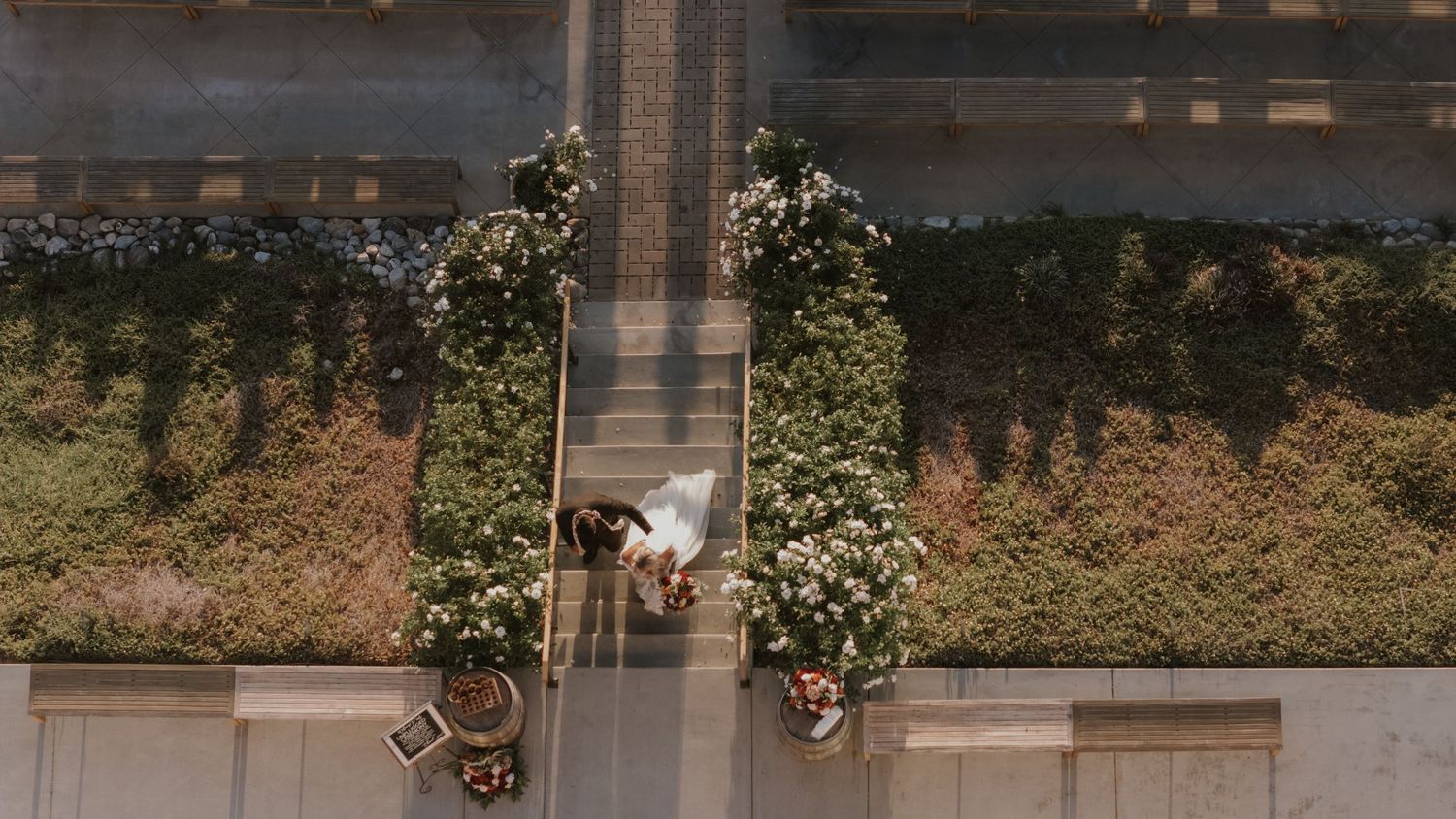 Overhead view of decorated wedding aisle with greenery and flowers.