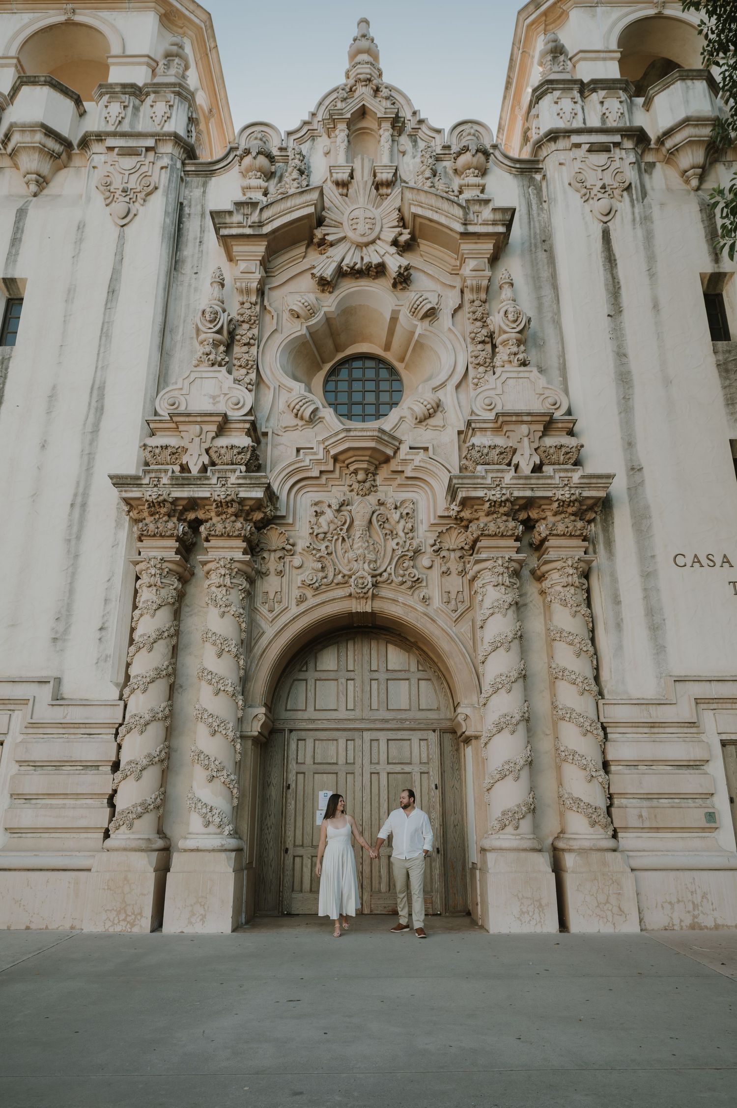 Ornate white baroque architecture with decorative stone carvings and archways in a historic building facade.