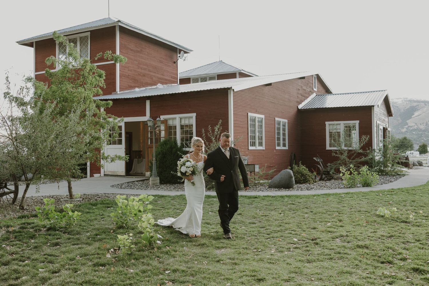 Scenic view of a brick venue building set against rolling hills and natural landscape.