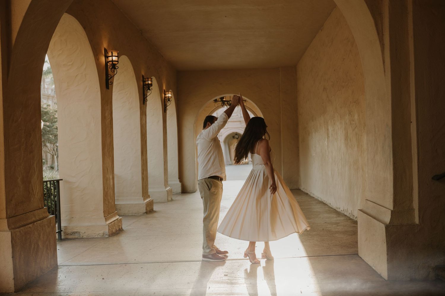 Sunlit archways and columns create dramatic shadows in a historic colonnade walkway.
