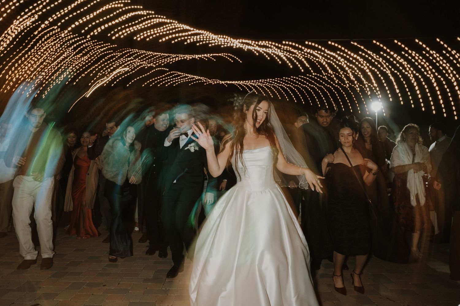 Wedding celebration dance floor with decorative string lights creating a magical ceiling effect.