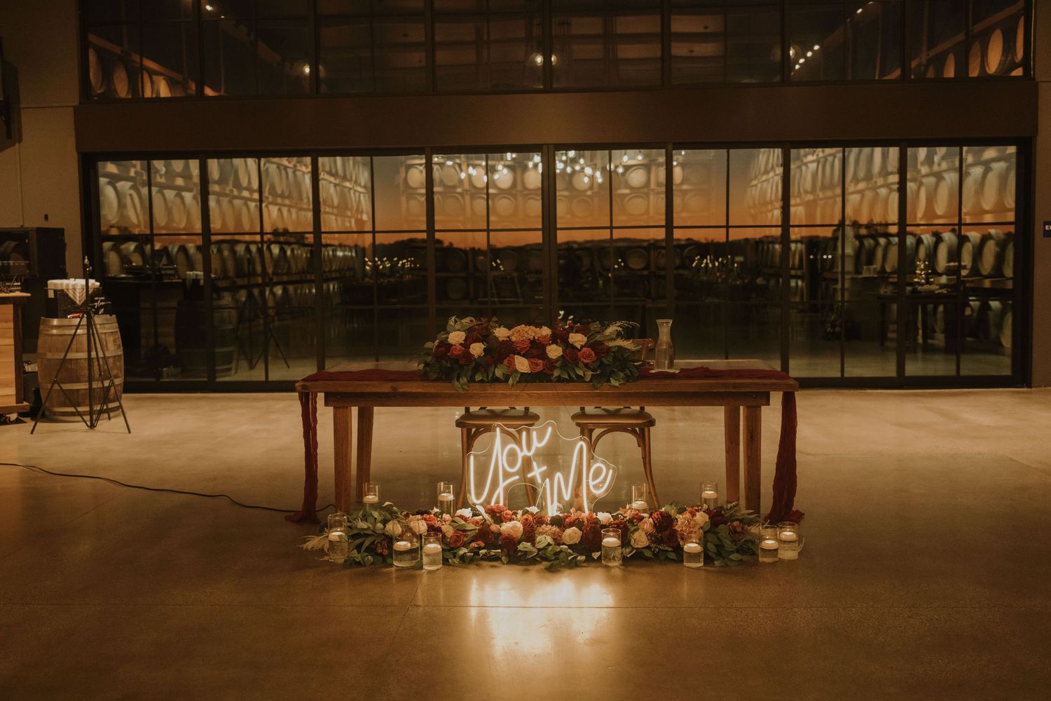 Elegant wedding reception venue with rustic wooden tables and warm ambient lighting.