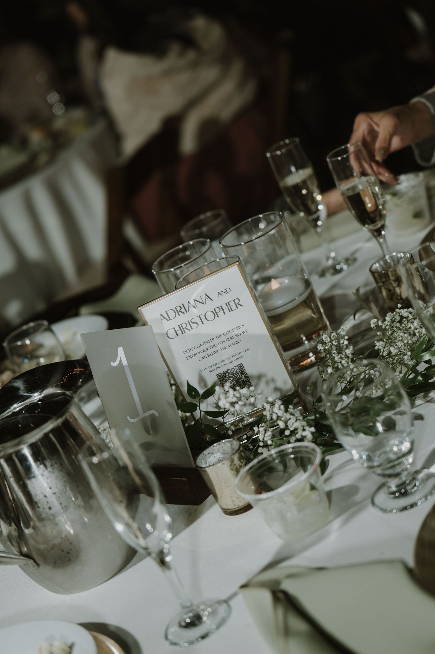 Formal wedding reception table settings with name cards and delicate floral arrangements.