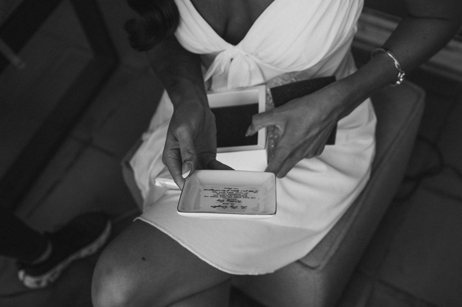 Black and white close-up of hands holding papers during a wedding ceremony.
