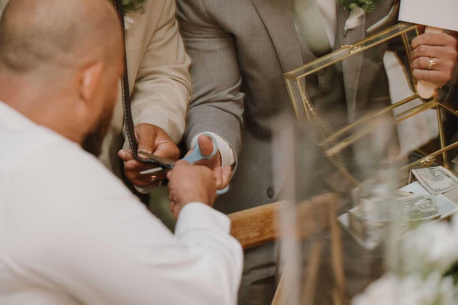 Groom placing a wedding ring on his partner's finger during an intimate outdoor wedding ceremony.