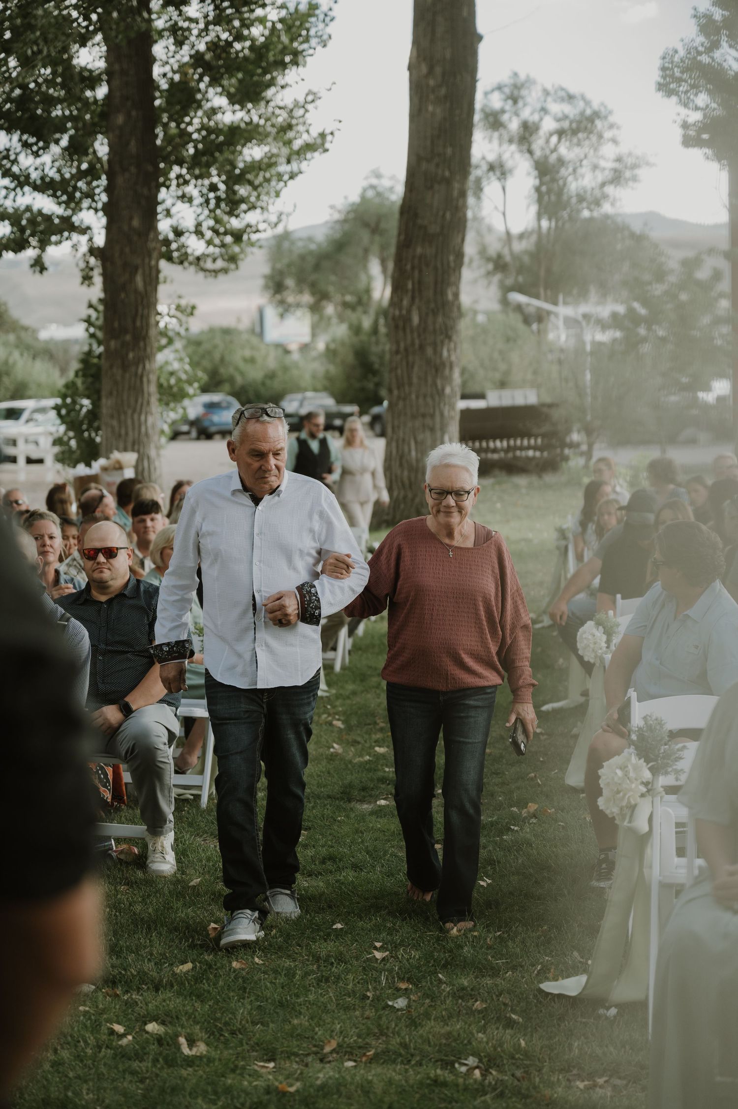 Wedding guests gathering on a grassy lawn during an outdoor celebration.