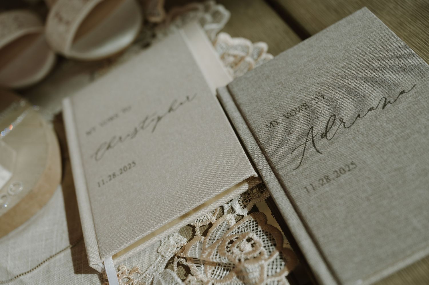 Wedding vow books with handwritten text displayed on lace fabric.