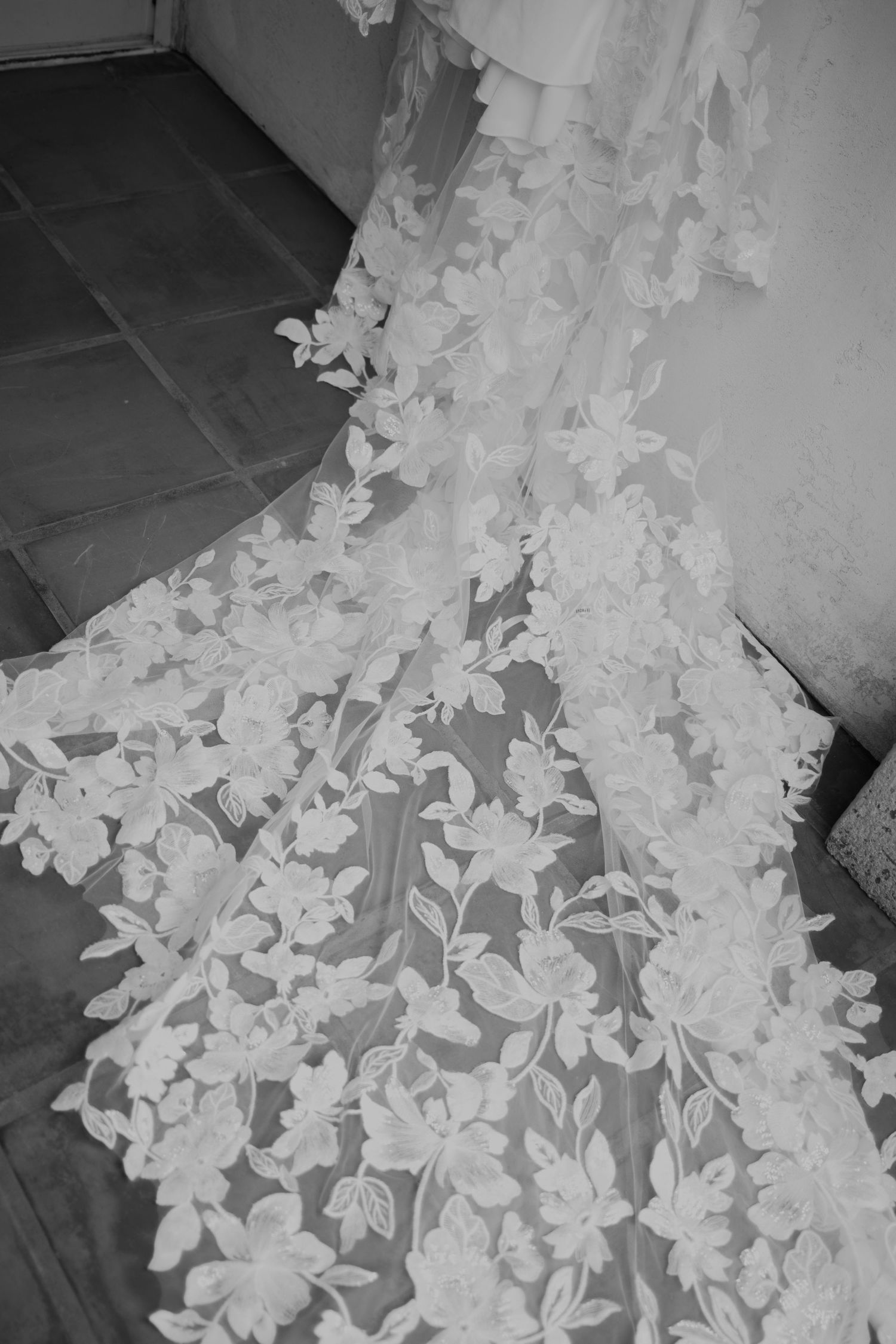 Detailed lace pattern on a white wedding dress with delicate floral appliques.