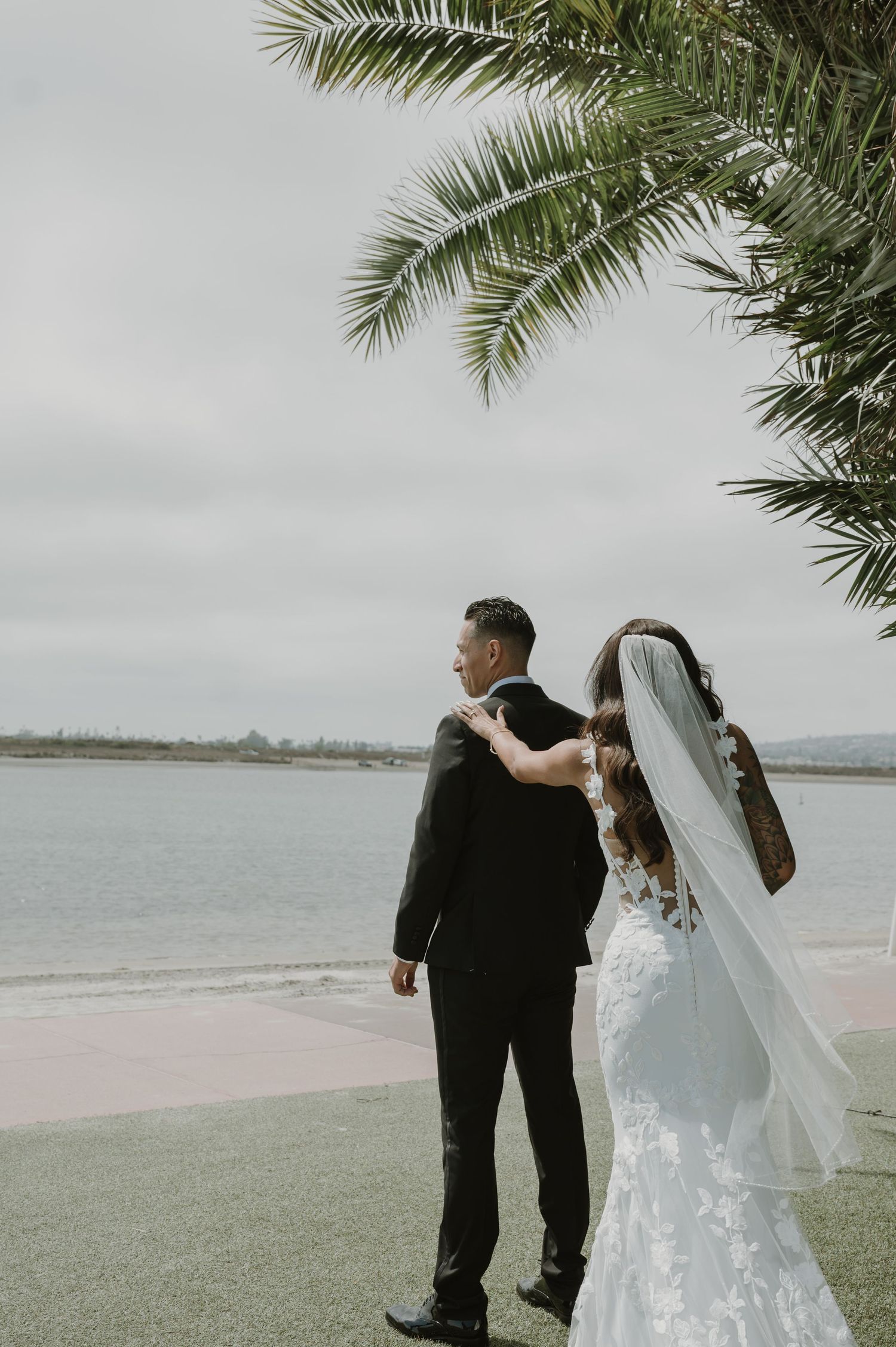 Seaside wedding photos with palm trees and ocean views in soft muted tones.