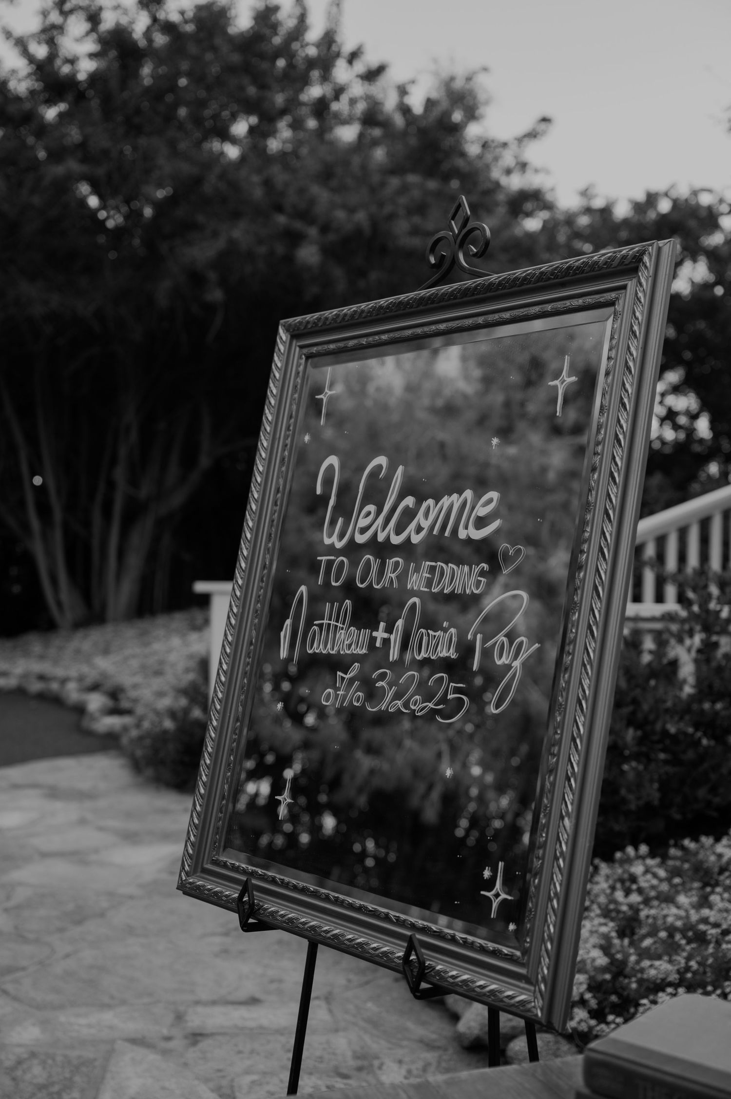 Black and white welcome wedding sign reading Matthew and Maria Paz with wedding date on easel.