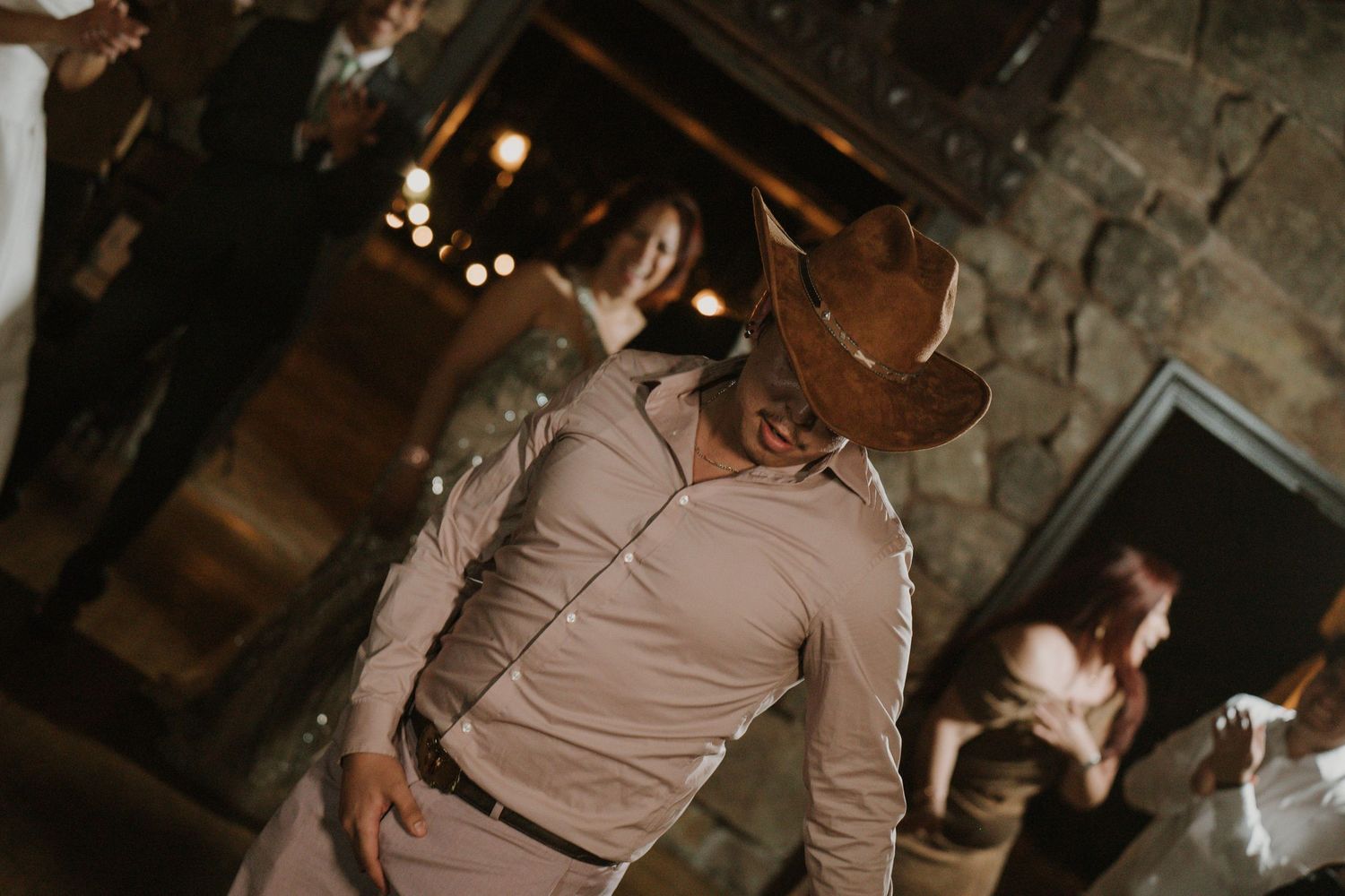 Wedding celebration captured in warm tones at a rustic stone venue.