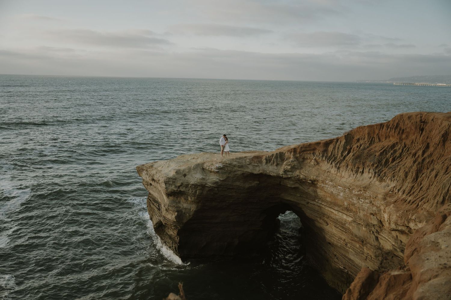 Dramatic coastal cliffs and ocean views create a stunning backdrop for a wedding photoshoot.