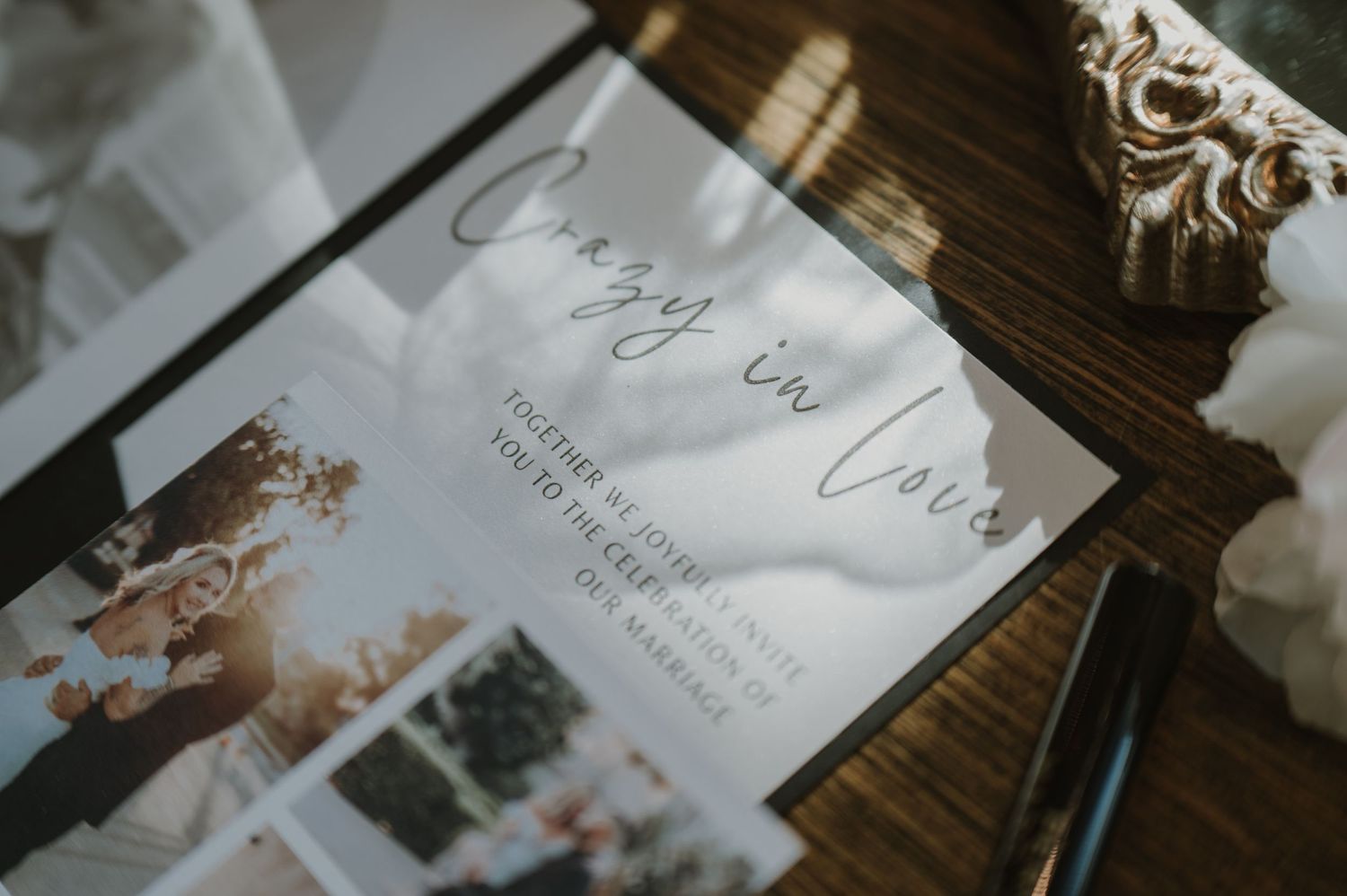 Wedding invitations and envelopes arranged on a rustic wooden surface with elegant calligraphy details.