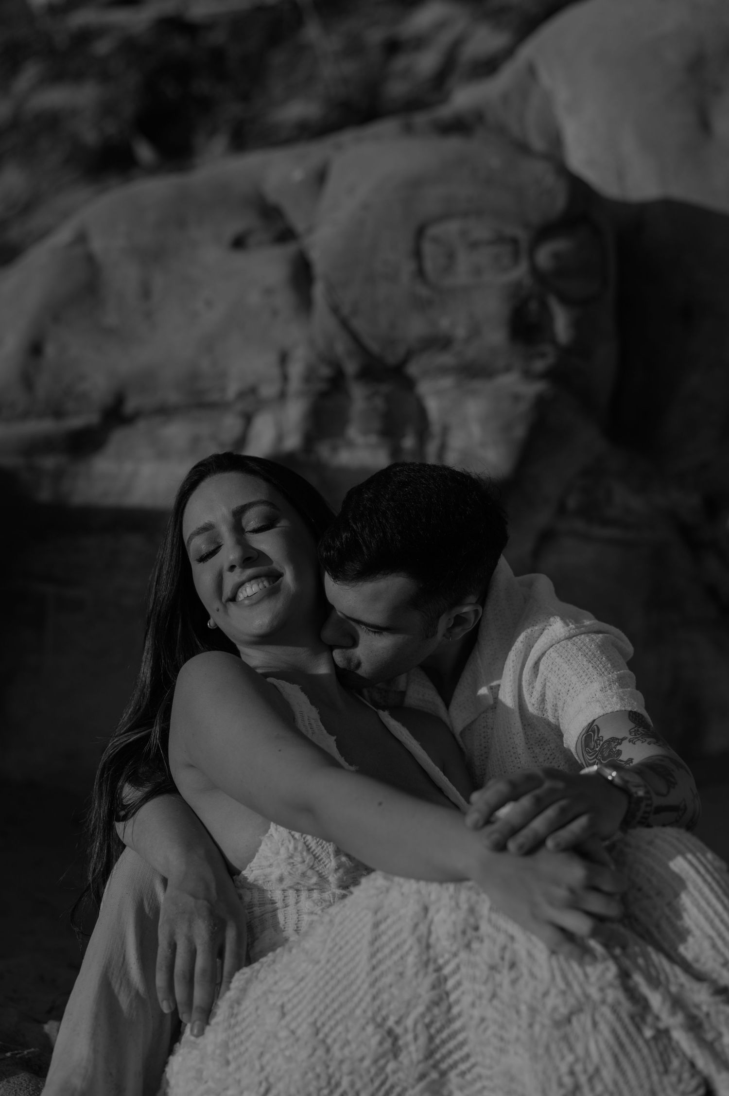 Black and white intimate photo sequence showing tender moments shared on a bed with soft lighting.