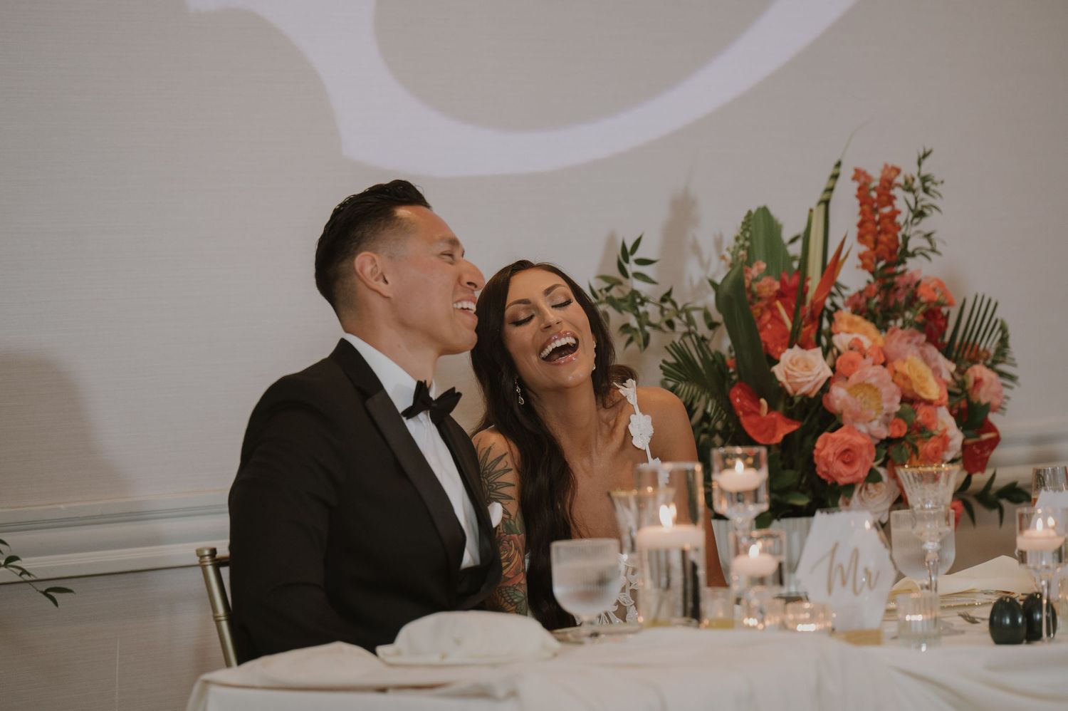 Elegant wedding reception setup with coral floral arrangements and candlelit tables.