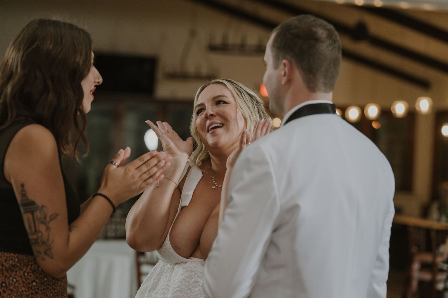 Joyful bride laughing and celebrating with wedding guests during the reception festivities.