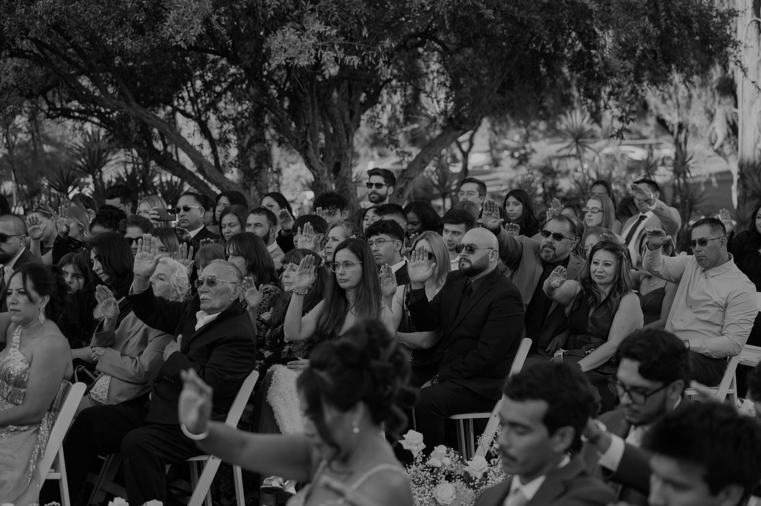 A black and white capture of wedding guests watching the ceremony unfold.