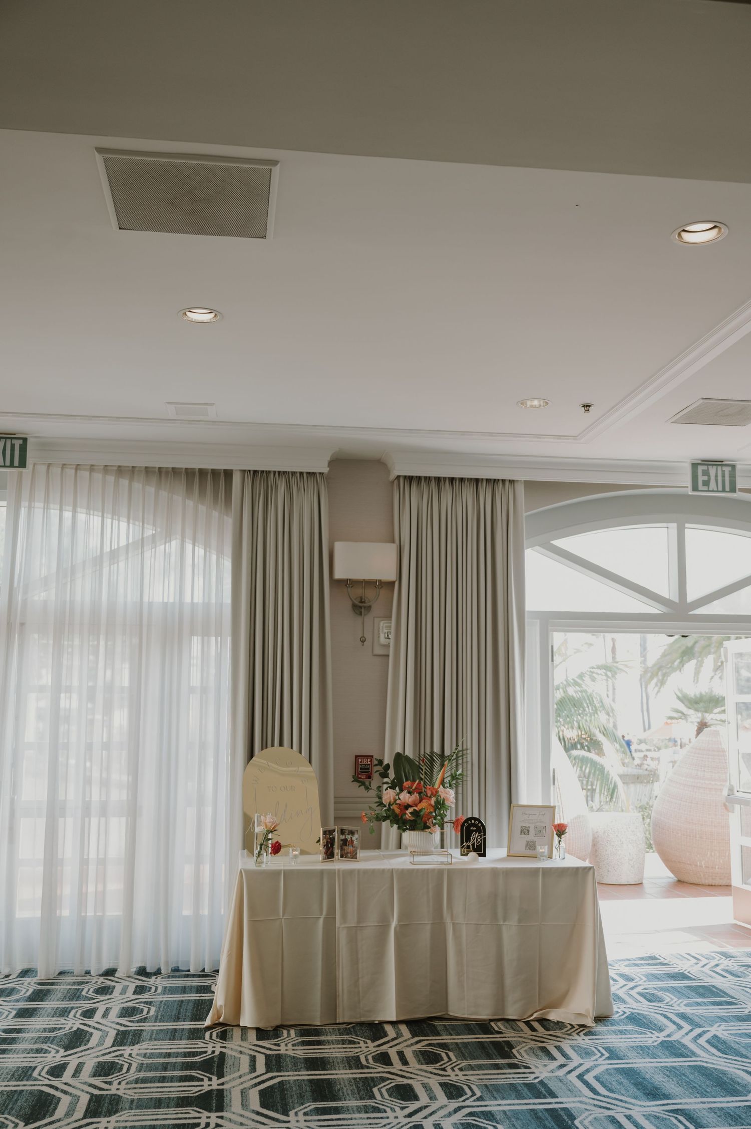Light-filled banquet room with white curtains and coastal views.