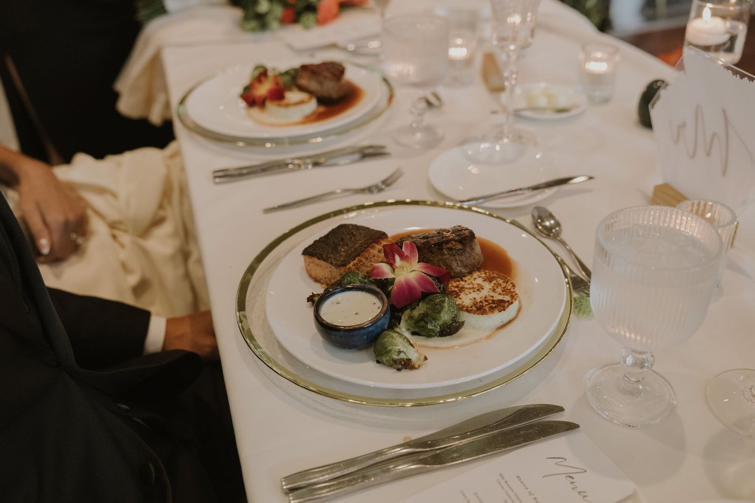 Elegant plated dinner service with fine dining presentation at wedding reception.