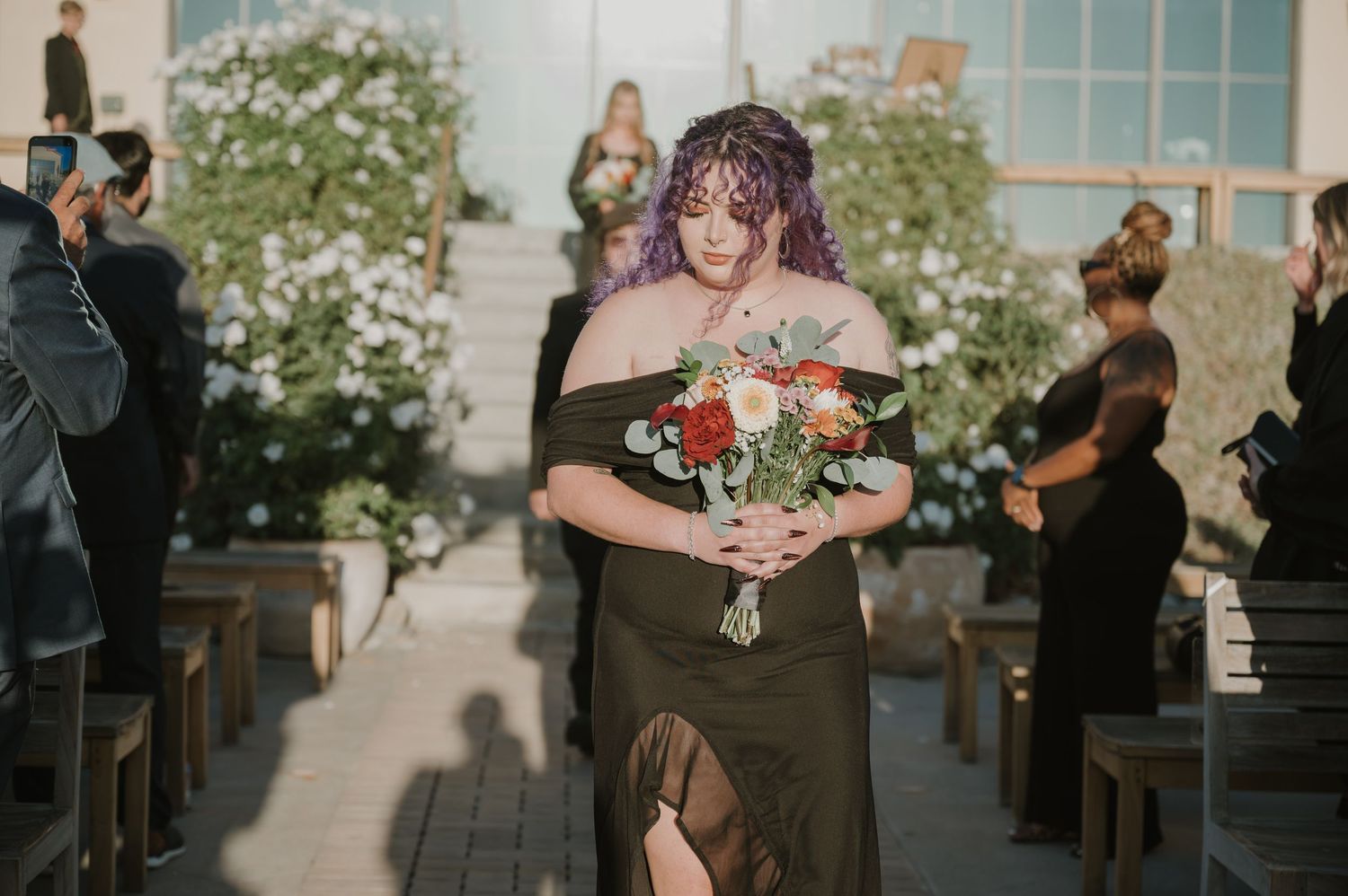 Wedding ceremony processional in an elegant indoor venue with floral decorations.