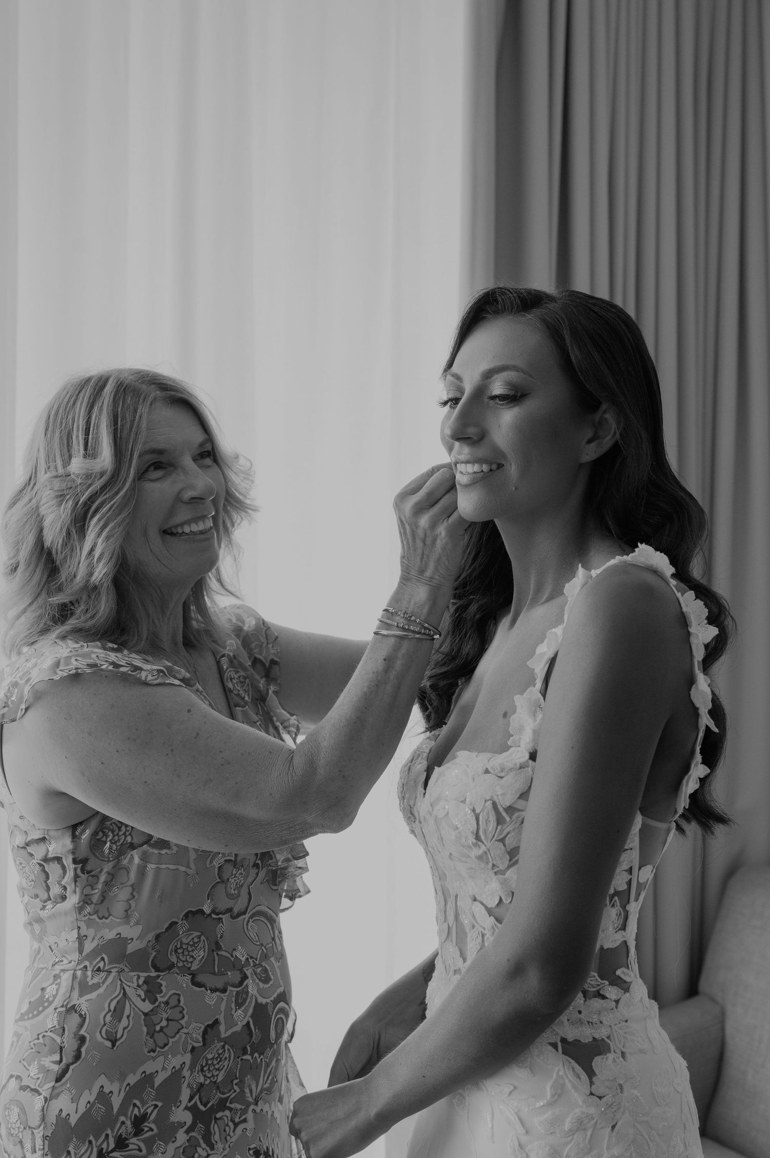 Candid black and white photos showing joyful laughter and emotions during wedding preparations.