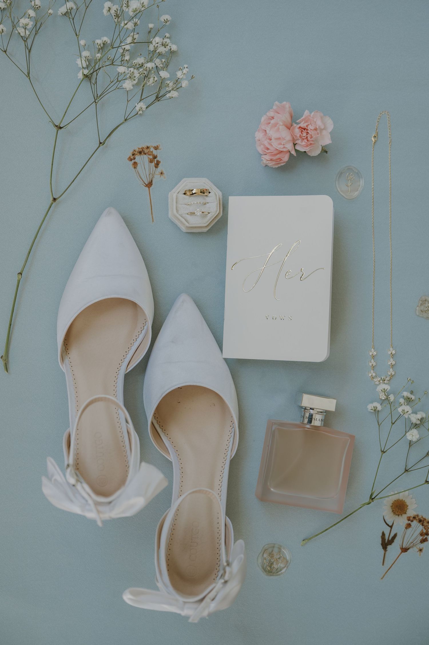 Elegant bridal flat shoes with bow, perfume, ring box, pink carnation, and 