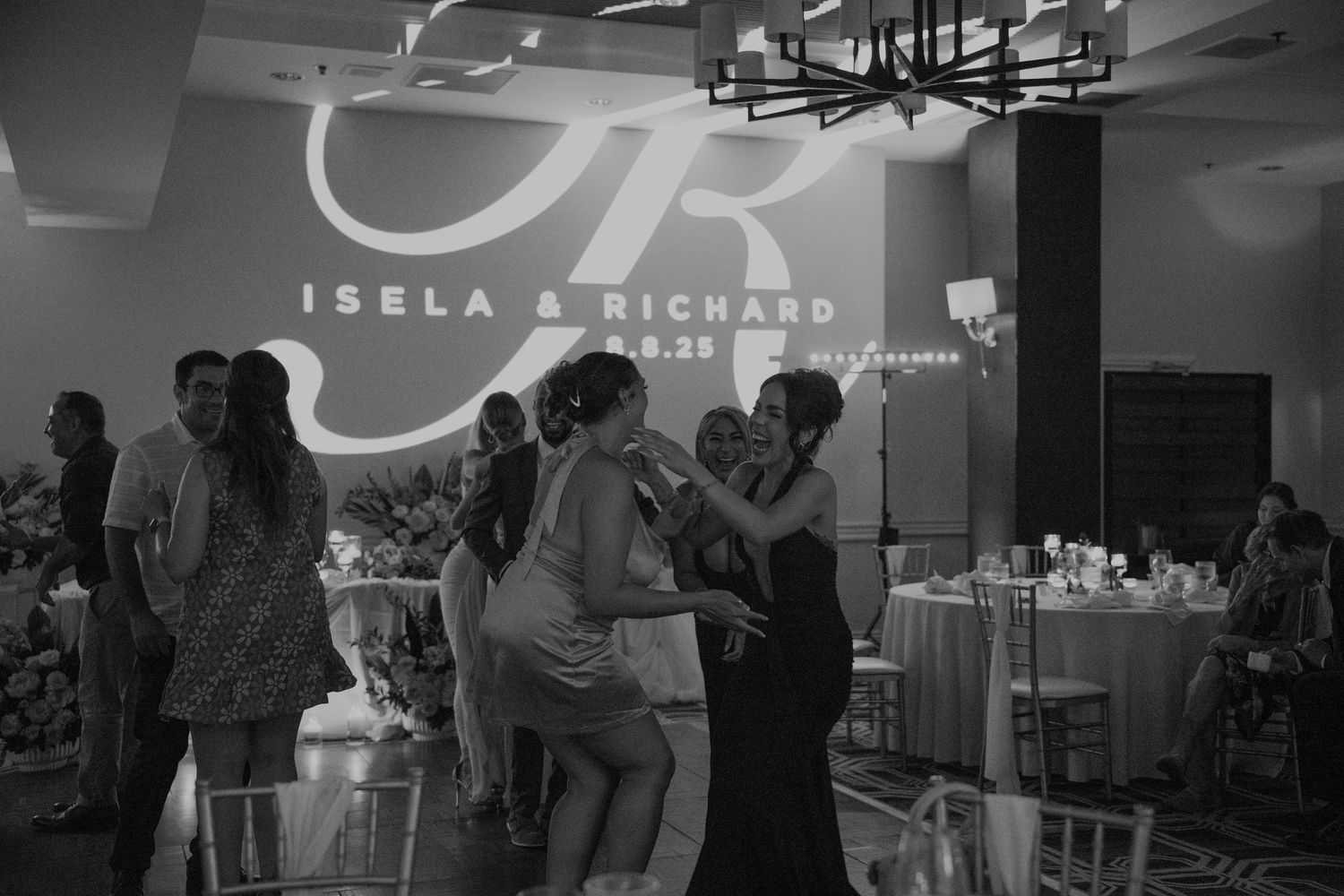 Modern wedding reception venue with projected names and decorative lighting.