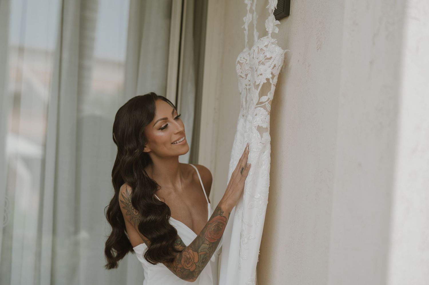 Elegant white wedding dress hanging in a bright, modern setting.