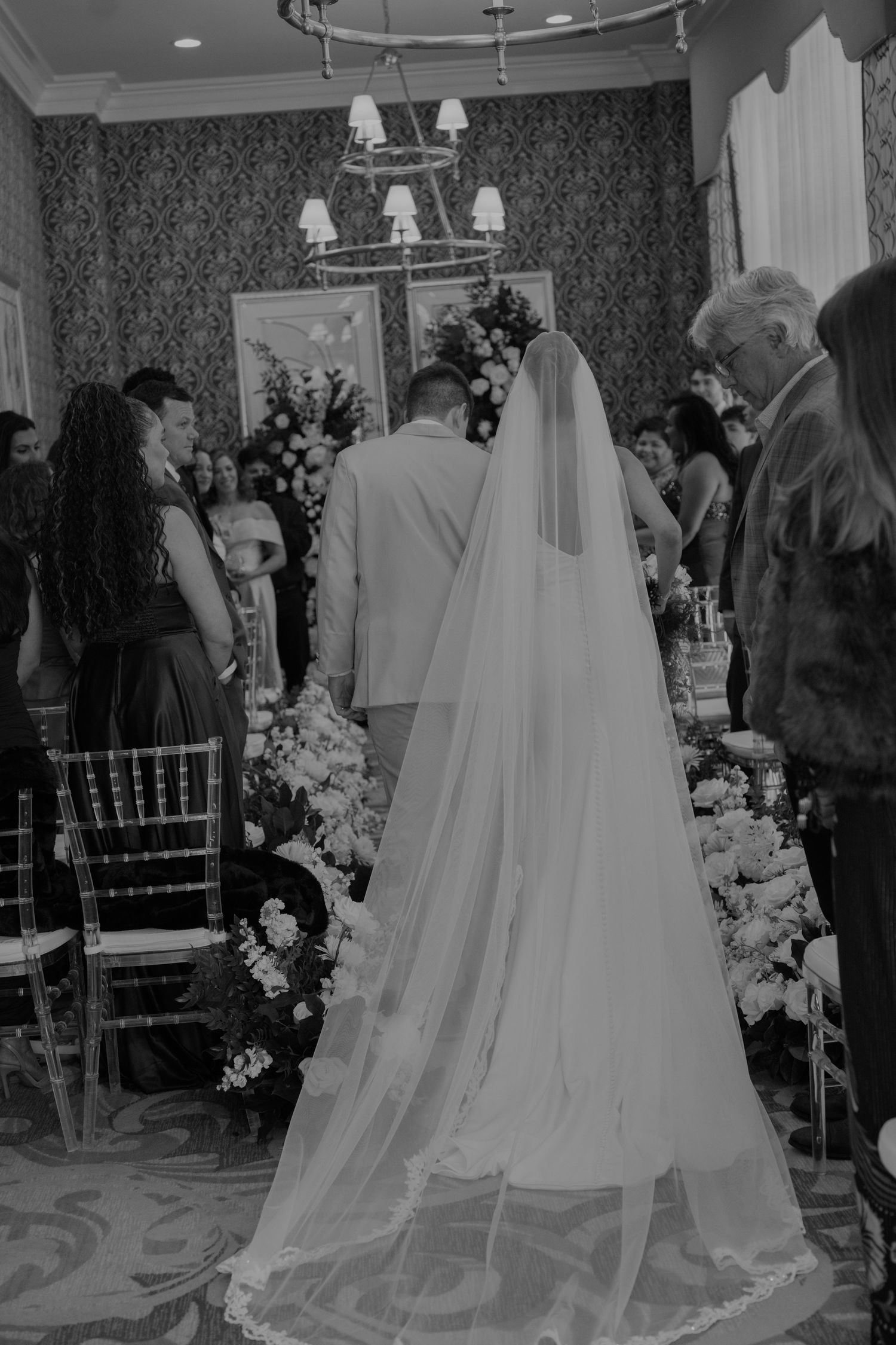 Wedding reception venue decorated with elegant white veils and floral arrangements.