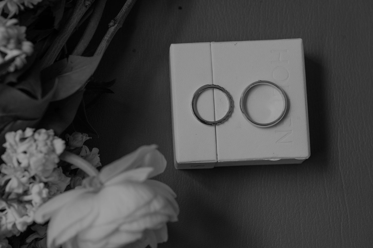 Wedding ceremony details including rings and documents in monochrome style.