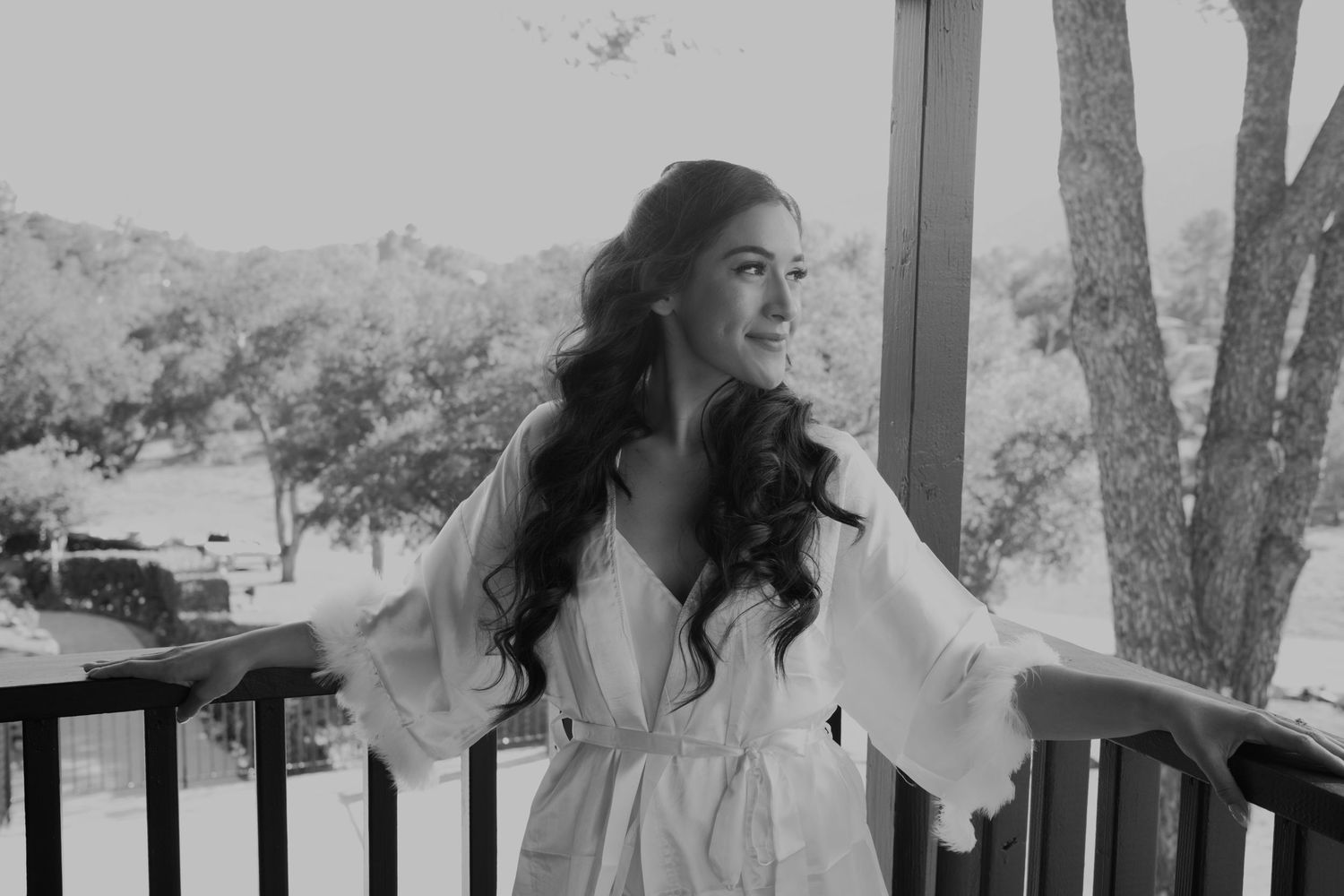 Black and white portrait of someone in a robe on a balcony.