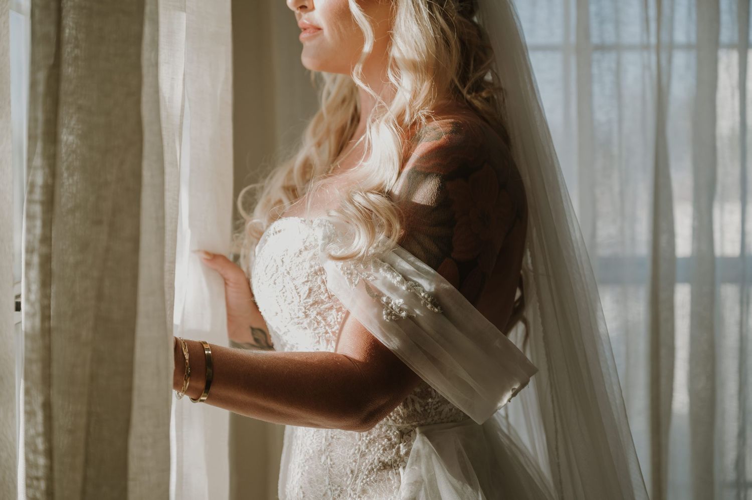 Ethereal bridal portrait with sunlight streaming through translucent curtains.