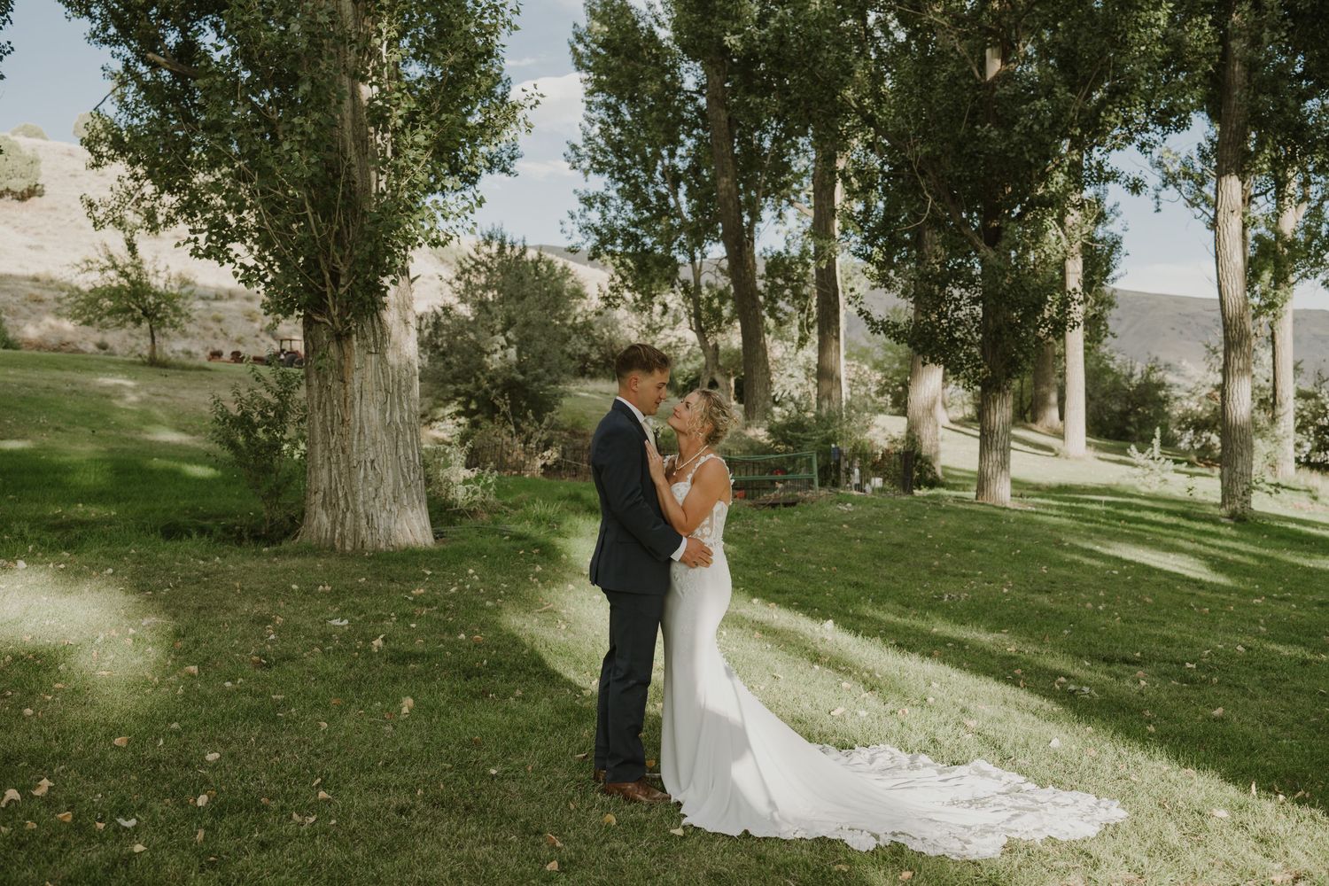 A couple shares their wedding day first look in a serene outdoor setting with tall trees.