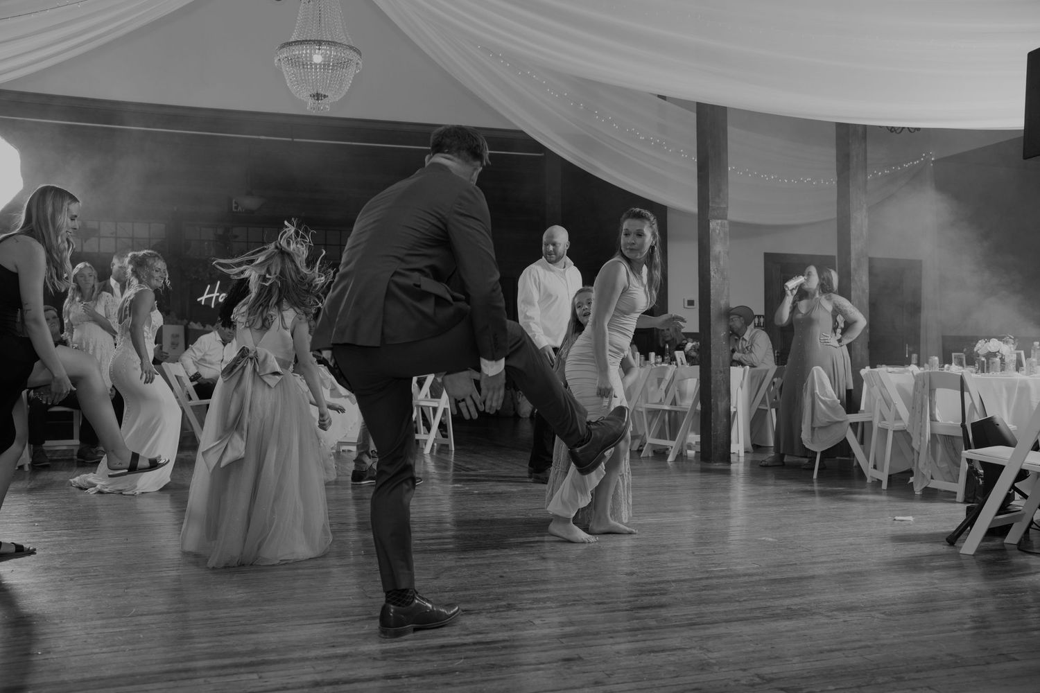 Wedding reception dance floor filled with guests dancing and celebrating in a banquet hall.