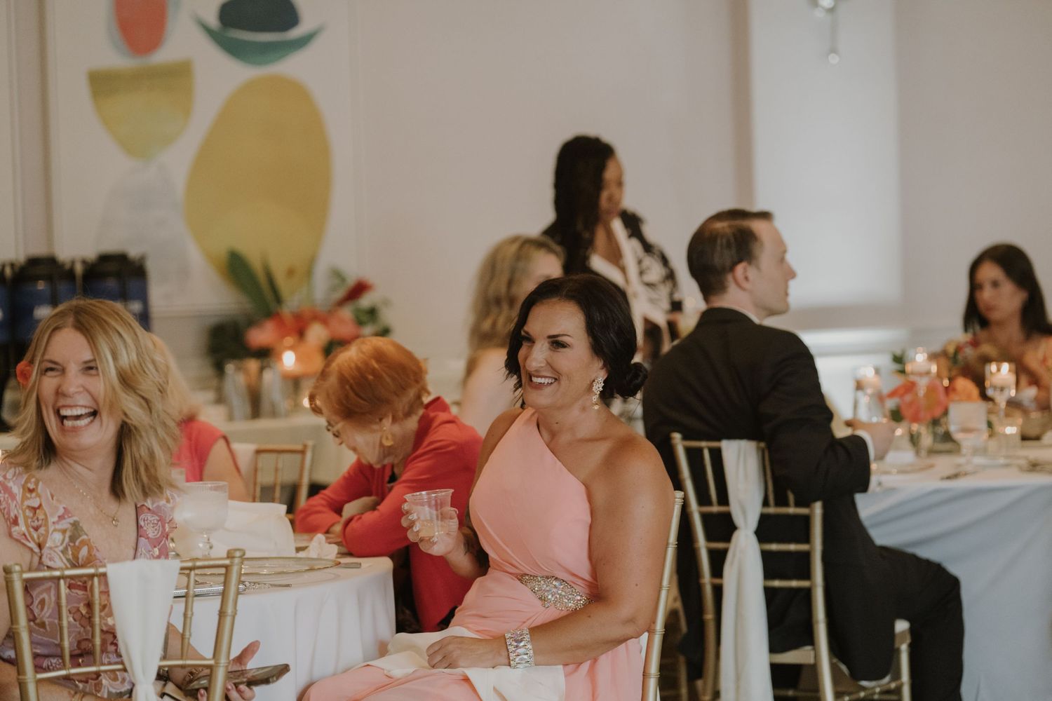 Wedding guests enjoying a reception dinner at elegantly decorated tables.