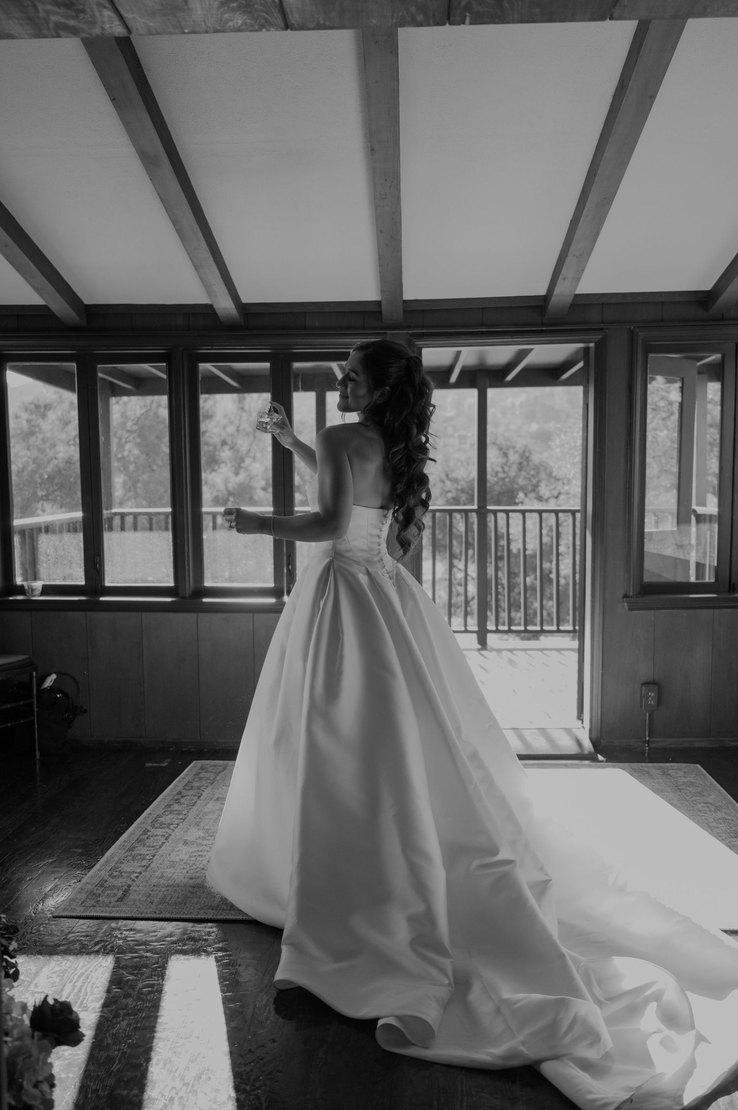 Interior space with sunlight streaming through windows and a flowing white dress in view.