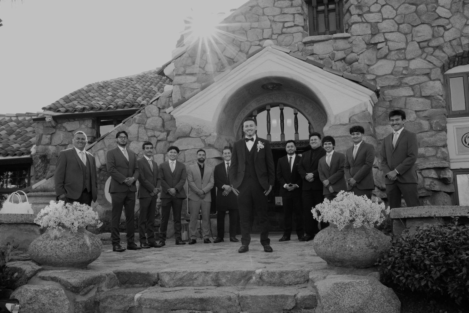 Vintage black and white photo of wedding party gathered on stone church steps.