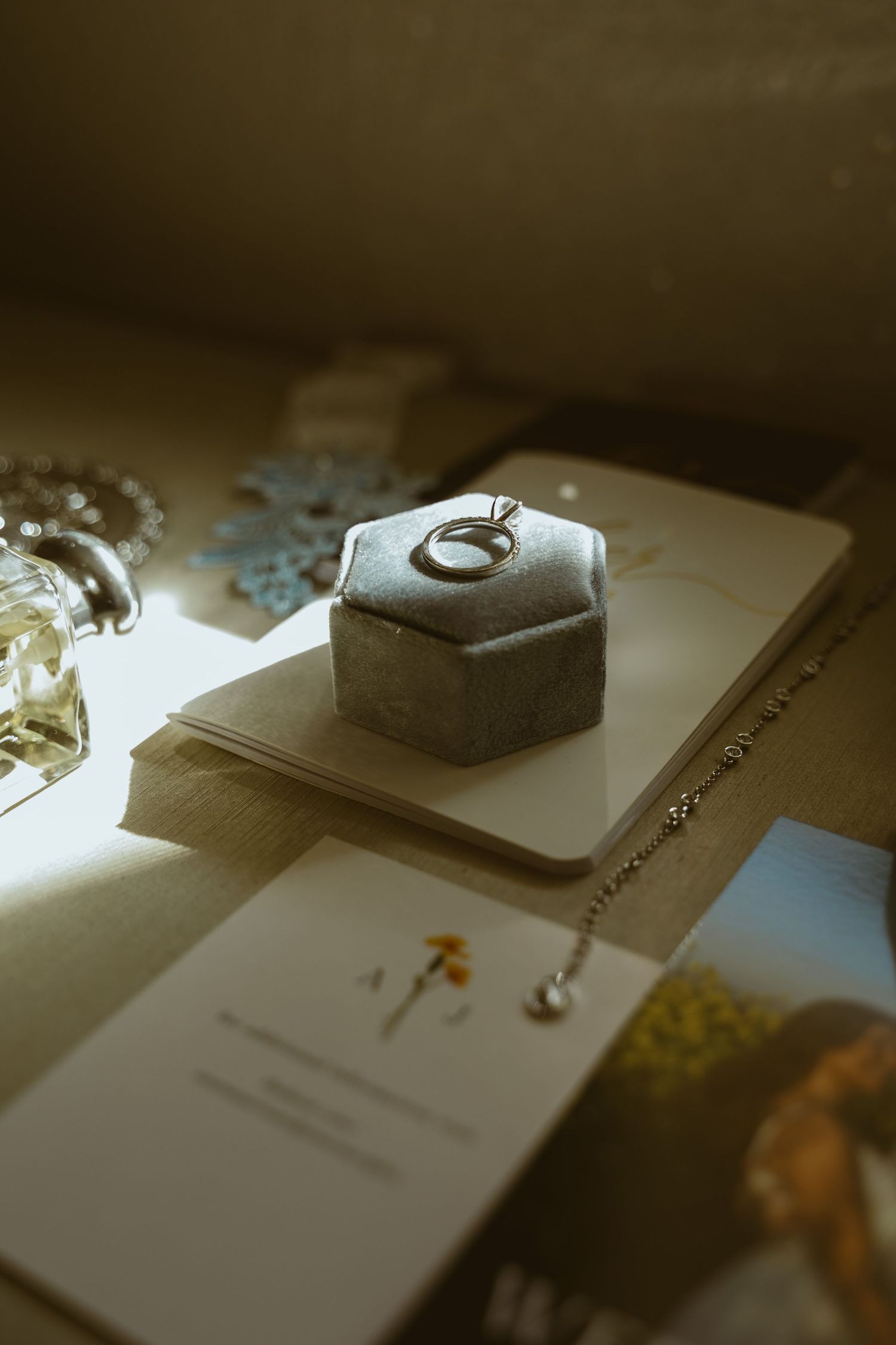 Wedding rings displayed on elegant gray ring boxes in artistic lighting.