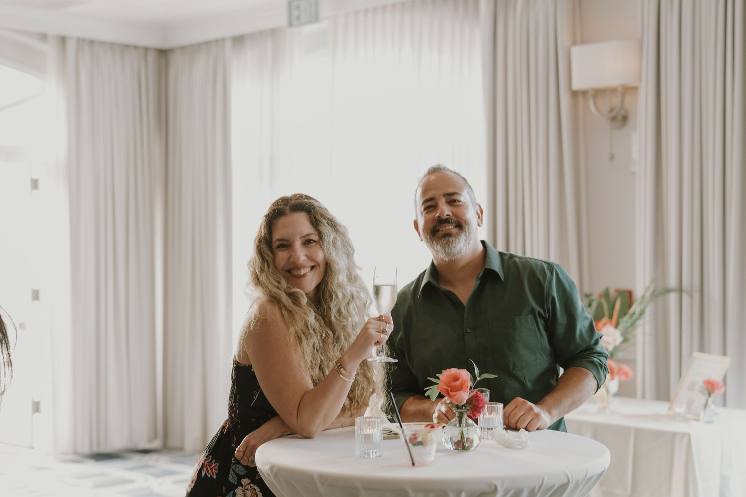 A couple celebrates with champagne at an elegant wedding reception.