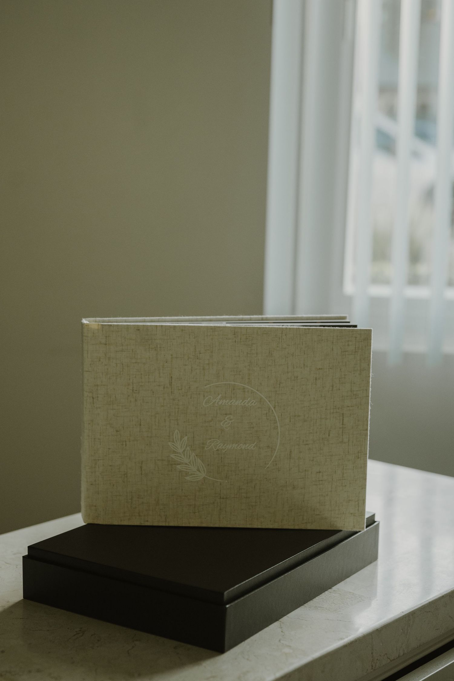 A minimalist book or document lying on a white surface with soft natural lighting from a window.