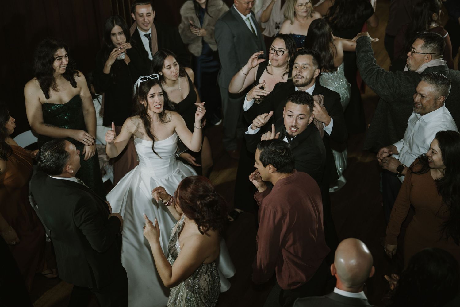Lively wedding reception with guests dancing and celebrating in formal attire.