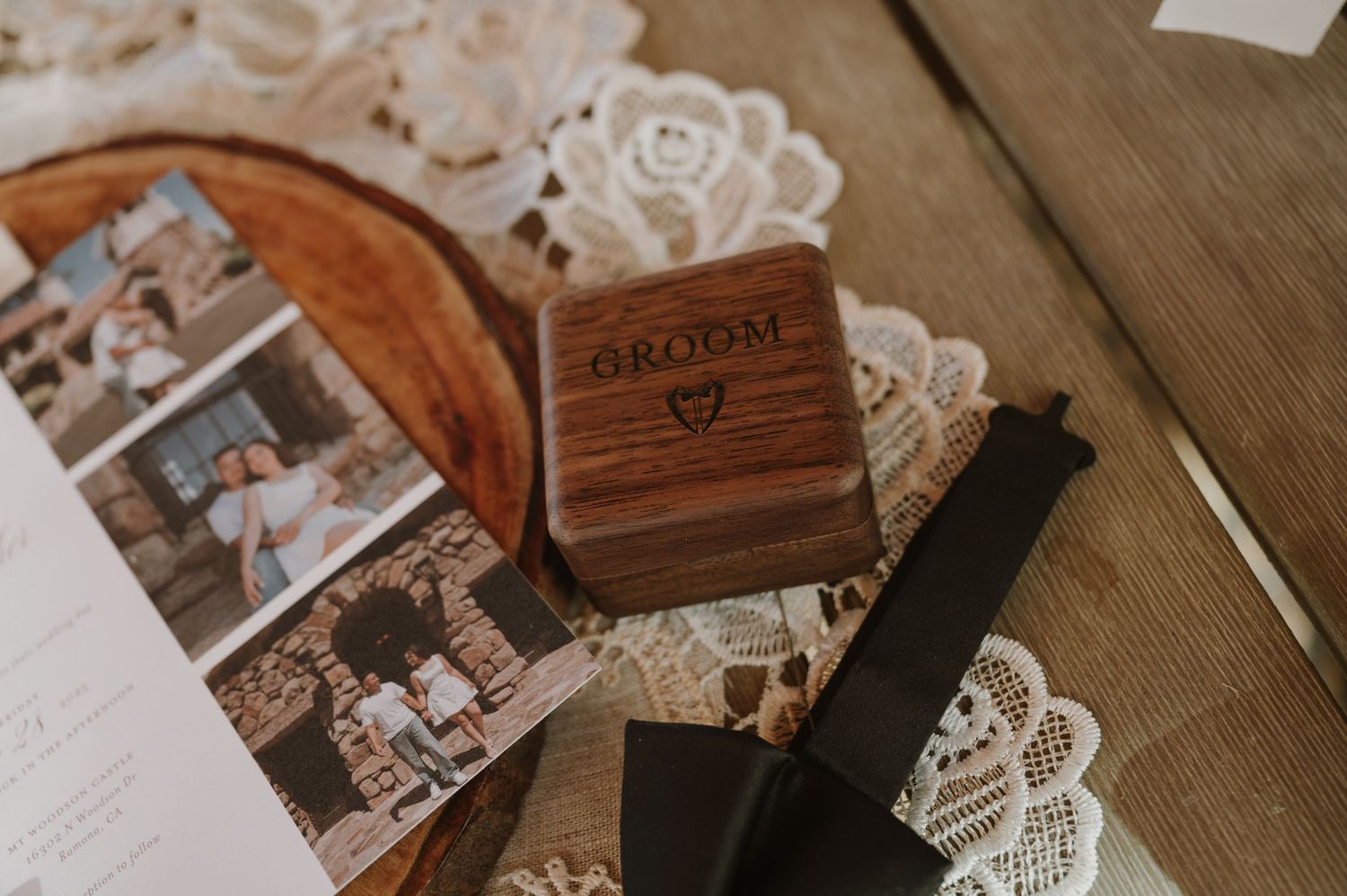 Wedding details including lace and wooden boxes arranged on rustic table.