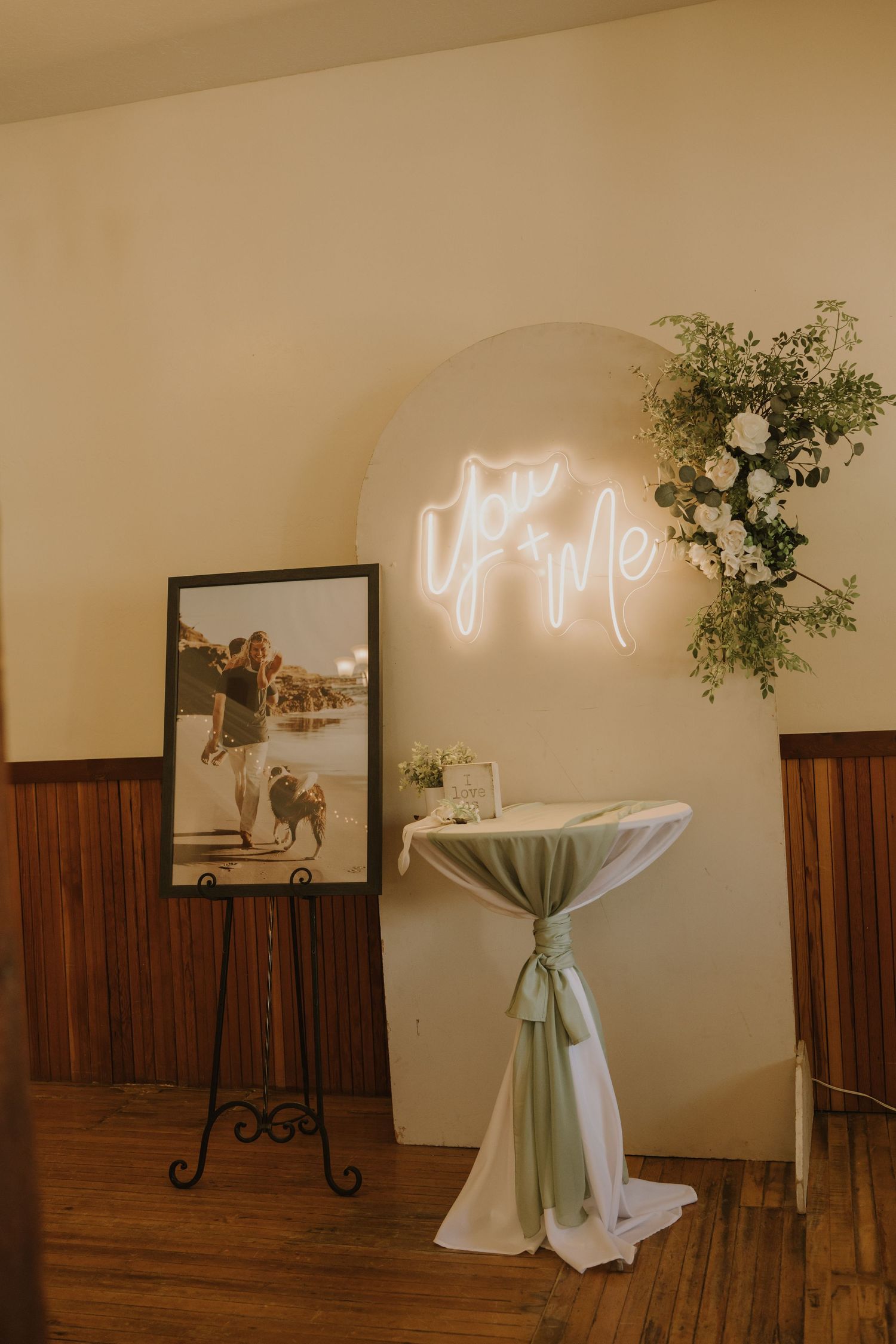 Modern wedding venue interior with neon sign decor and minimalist white and wood accents.