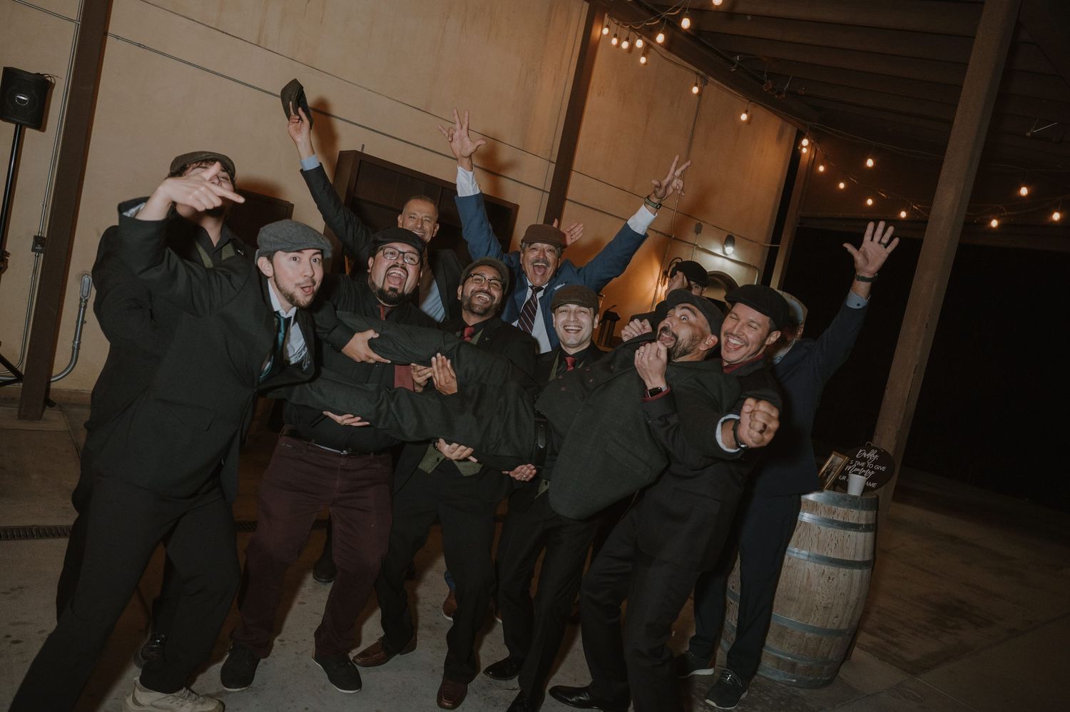 Large group of wedding guests celebrating with sparklers at night.