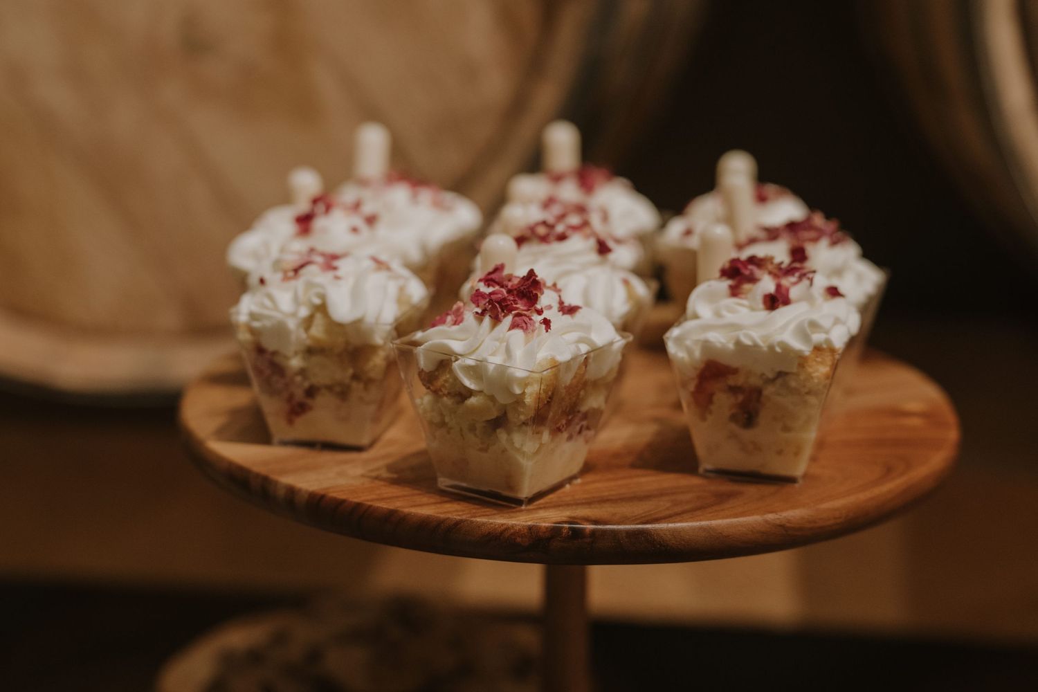 Artfully plated desserts on wooden serving boards at wedding reception.